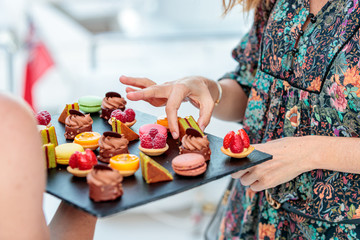 hands of a woman with desserts