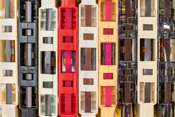 stack of old retro cassette tapes with tape ends showing on yellow background