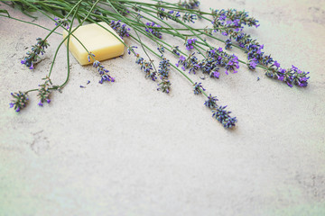 Lavender flowers and natural soap for bodycare on concrete background. Flat lay, top view. Spa massage concept. Copy space.