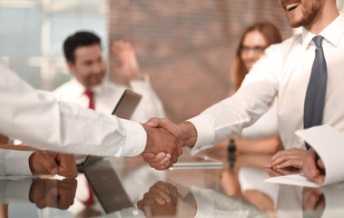 handshake of business partners on the background of the deskto