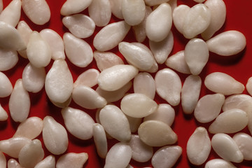 Fototapeta na wymiar White sesame seeds on a red background
