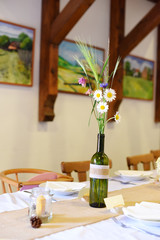 Wedding. Banquet. The chairs and round table for guests, served with cutlery, flowers and crockery and covered with a tablecloth.