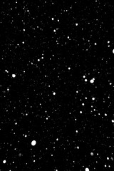 falling snow on a black background, snowfall at night, white chaotic spots on a black background