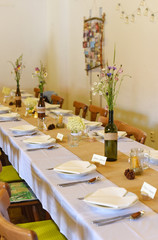 Wedding. Banquet. The chairs and round table for guests, served with cutlery, flowers and crockery and covered with a tablecloth.