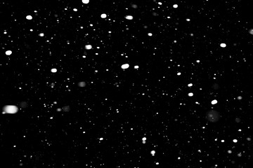 falling snow on a black background, snowfall at night, white chaotic spots on a black background