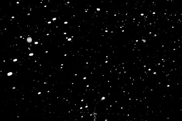 falling snow on a black background, snowfall at night, white chaotic spots on a black background