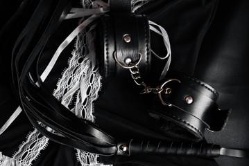 Leather black whip and handcuffs for domination and hard sex