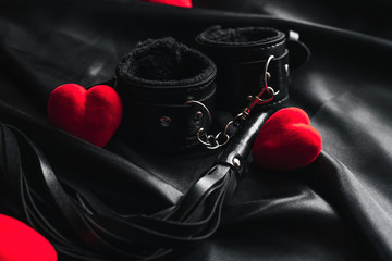Handcuffs and whip for BDSM sex with red hearts.