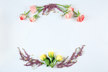 Feminine frame background made of various flowers with a lot of copy space for text. Close up, top view, flat lay.