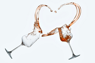 Wein spritzt aus zwei Gläsern und bildet ein Herz