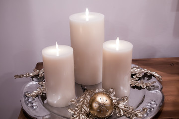 Christmas candles and decorations on silver plate with gold ornament