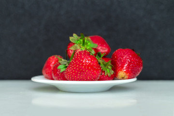 Ripe strawberries on a white plate