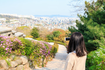 Asian woman taking pictures of Aerial view of Seoul city with smartphone