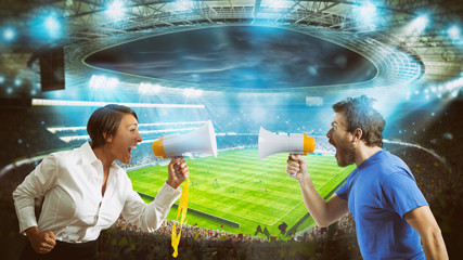 Supporters of opposing teams shout against each other with a megaphone at the stadium during a...