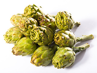 Fototapeta premium Uncooked green artichokes on a white surface