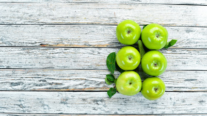 Green apples on a white wooden background. Fruits. Top view. Free space for text.