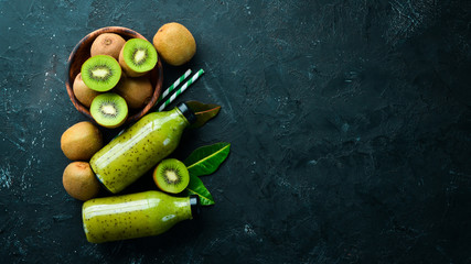 Green Smoothies with fresh kiwi and kiwi on a black background Wooden. Rustic style. Fruits. Top view. Free space for text.