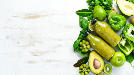 Fresh organic green smoothie on a wooden background. Fresh Green Fruits and Vegetables. Organic food. Rustic style. Top view. Free space for text.
