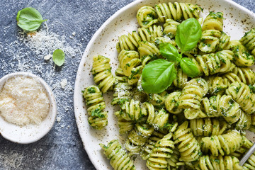 Pasta with pesto and parmesan on a concrete background. View from above.