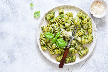 Vegan pasta with spinach, basil and parmesan. Lunch on the kitchen table.