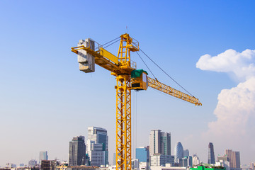 Crane is used in the construction of high buildings for tool of large industry under the blue sky and white clouds.