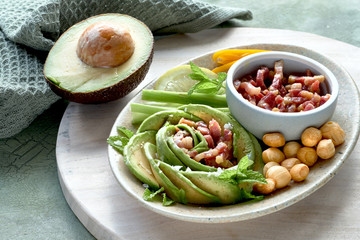 Keto diet, close-up on avocado rose salad with bacon cubes and smoked cheese