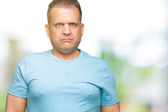 Middle age arab man wearing blue t-shirt over isolated background Relaxed with serious expression on face. Simple and natural looking at the camera.