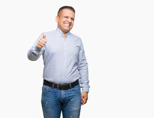 Middle age arab business man over isolated background doing happy thumbs up gesture with hand. Approving expression looking at the camera showing success.