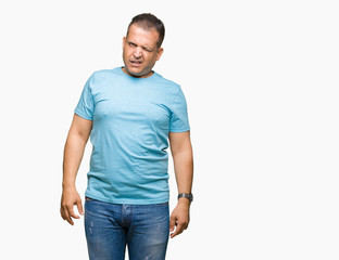 Fototapeta premium Middle age arab man wearing blue t-shirt over isolated background winking looking at the camera with sexy expression, cheerful and happy face.