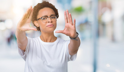 Beautiful young african american woman wearing glasses over isolated background Smiling doing frame using hands palms and fingers, camera perspective