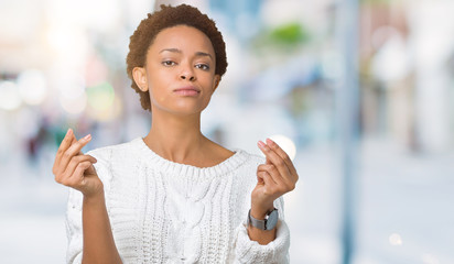 Beautiful young african american woman wearing sweater over isolated background Doing money gesture...