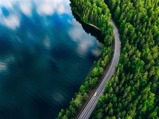 Fotobehang Blauwgroen Luchtmening van weg tussen groen bos en blauw meer in Finland