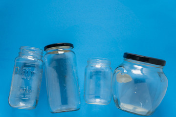 Isolated glass jars laid flat on blue background with room for copyspace on top