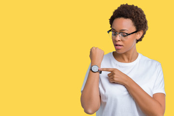 Beautiful young african american woman wearing glasses over isolated background In hurry pointing...