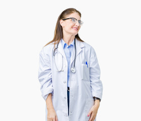 Middle age mature doctor woman wearing medical coat over isolated background looking away to side...