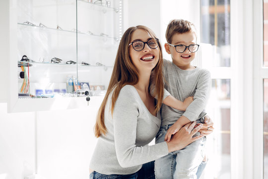 Mother with cute son. Family buy glasses