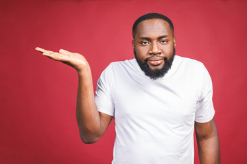 Closeup portrait of dumb clueless young african man, arms out asking why what's the problem, I...