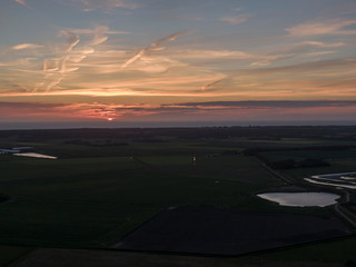 Aerial of sunset over agricultural meadowland and sea on the dutch island of Texel