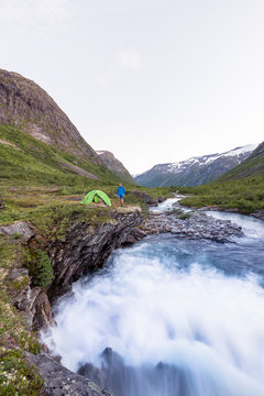 Eidsdalselva, M&macr;re og Romsdal, Norway: A male hiker at his camp on a cliff by the river.