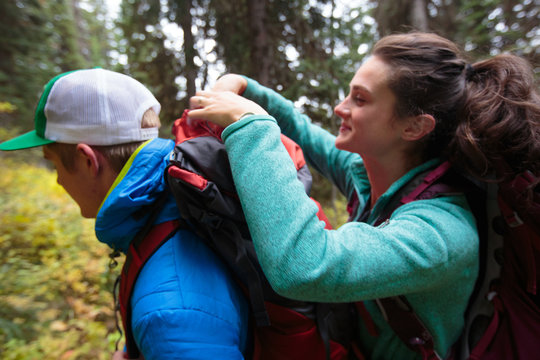 A female and male backpacker unloading items from an Osprey pack along the Siyeh Pass Trail in Glacier National Park in autumn.