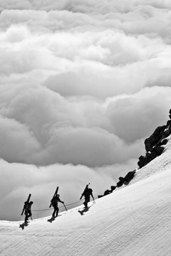 Skiers travers towards the summit on Mount Hood after climbing the south face.       