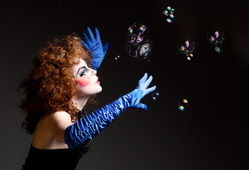 Woman mime with theatrical makeup and soap bubbles.