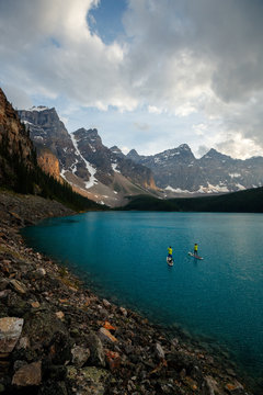 A couple stand up paddle board at Moraine Lake in Banff National Park in Canada.