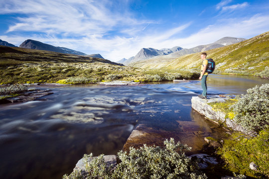 Rondane National Park, Norway: A male hiker by the river that flows from the Rondvassbu lodge towards Otta and comes by the parking in Spranget.