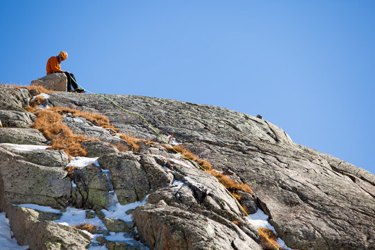 A man belays a climber up Wanting M5 WI4+, a mixed climb deep in the Wind River Range in Wyoming.