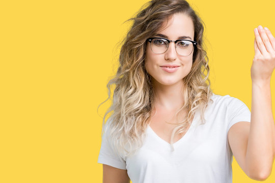 Beautiful young blonde woman wearing glasses over isolated background Doing Italian gesture with hand and fingers confident expression