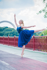 Fototapeta na wymiar Young ballerina in ballet costume dancing in city , feeling breath of big city life and freedom 