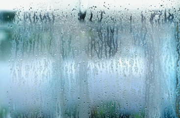Plakat drops on glass window. drops on glass in rainy day. rain outside window on rainy summer or autumn day. concept of rainy season. abstract texture of raindrops, wet glass background. templete design