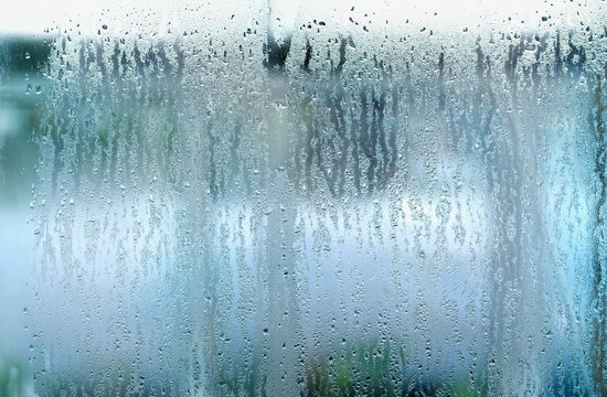 drops on glass window. drops on glass in rainy day. rain outside window on rainy summer or autumn day. concept of rainy season. abstract texture of raindrops, wet glass background. templete design © Ju_see