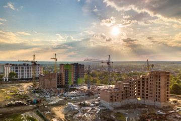 Aerial view of building site. Apartment or office building under construction. Tower cranes on...
